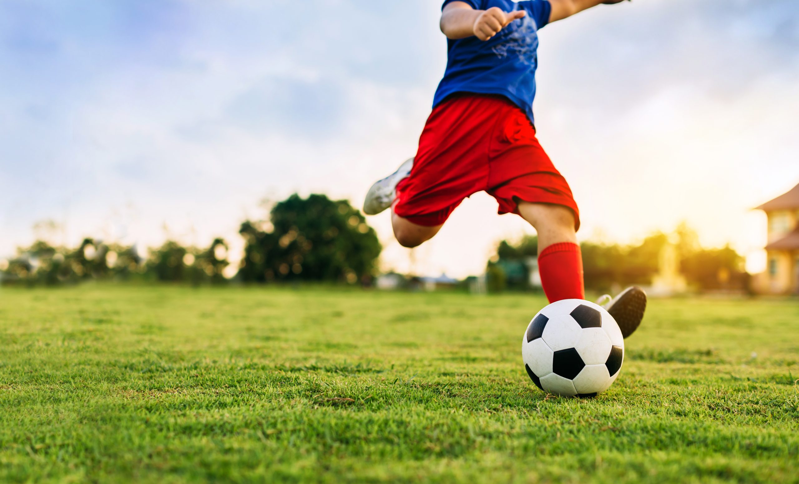 An action sport picture of a group of kids playing soccer footba