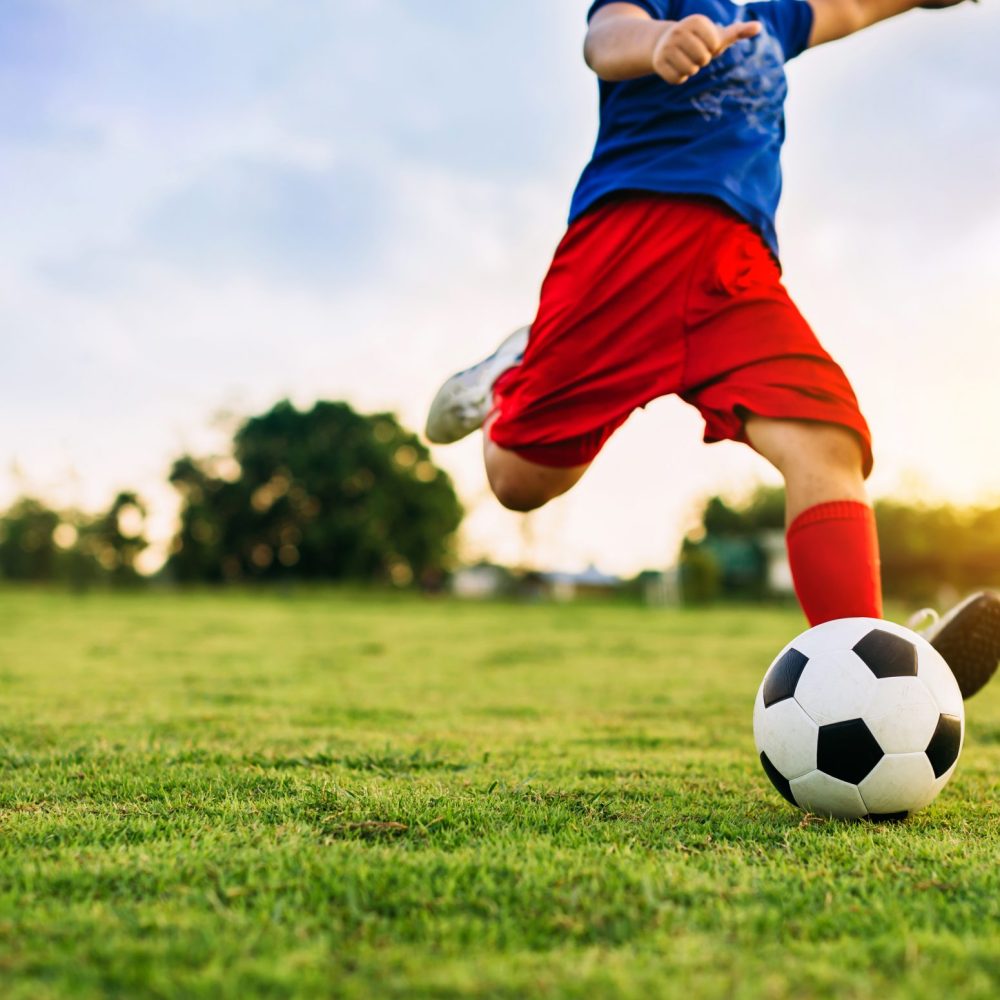 An action sport picture of a group of kids playing soccer footba